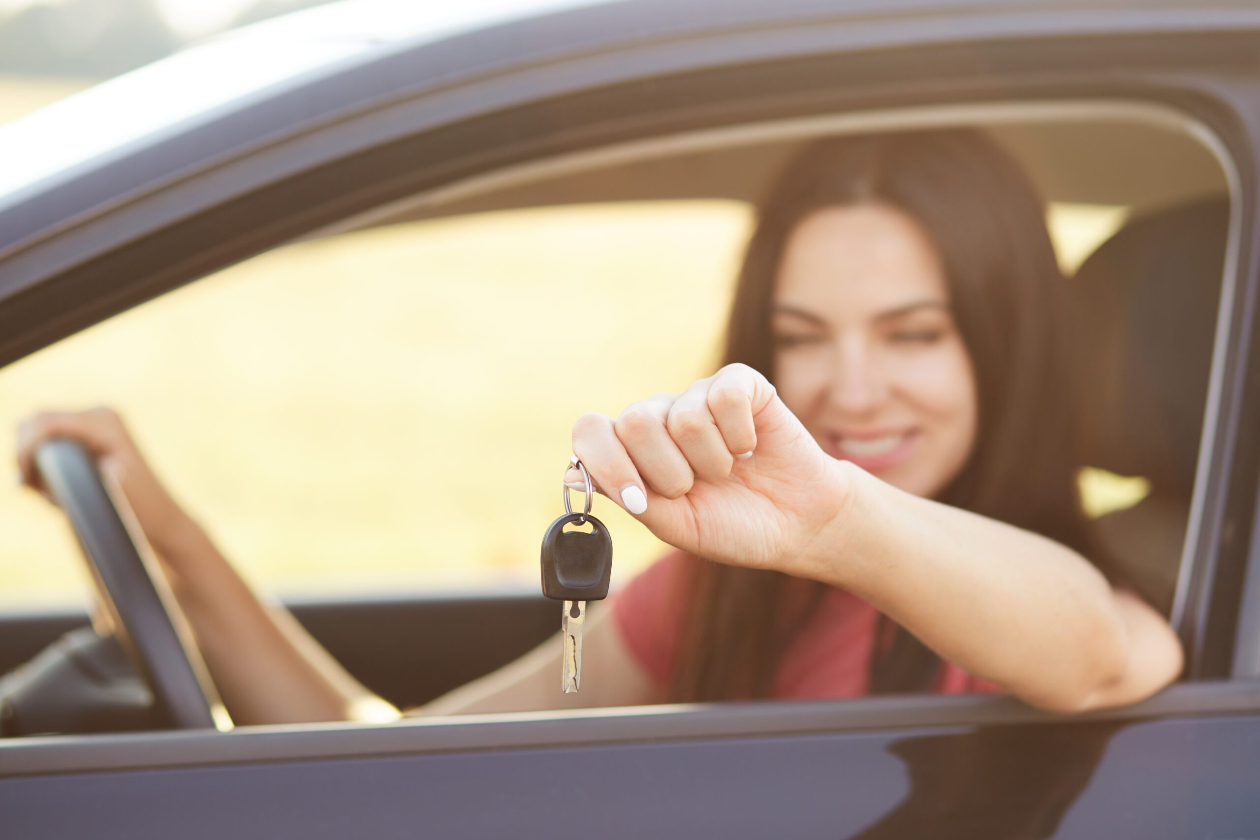 Mulher feliz com carro comprado com consórcio